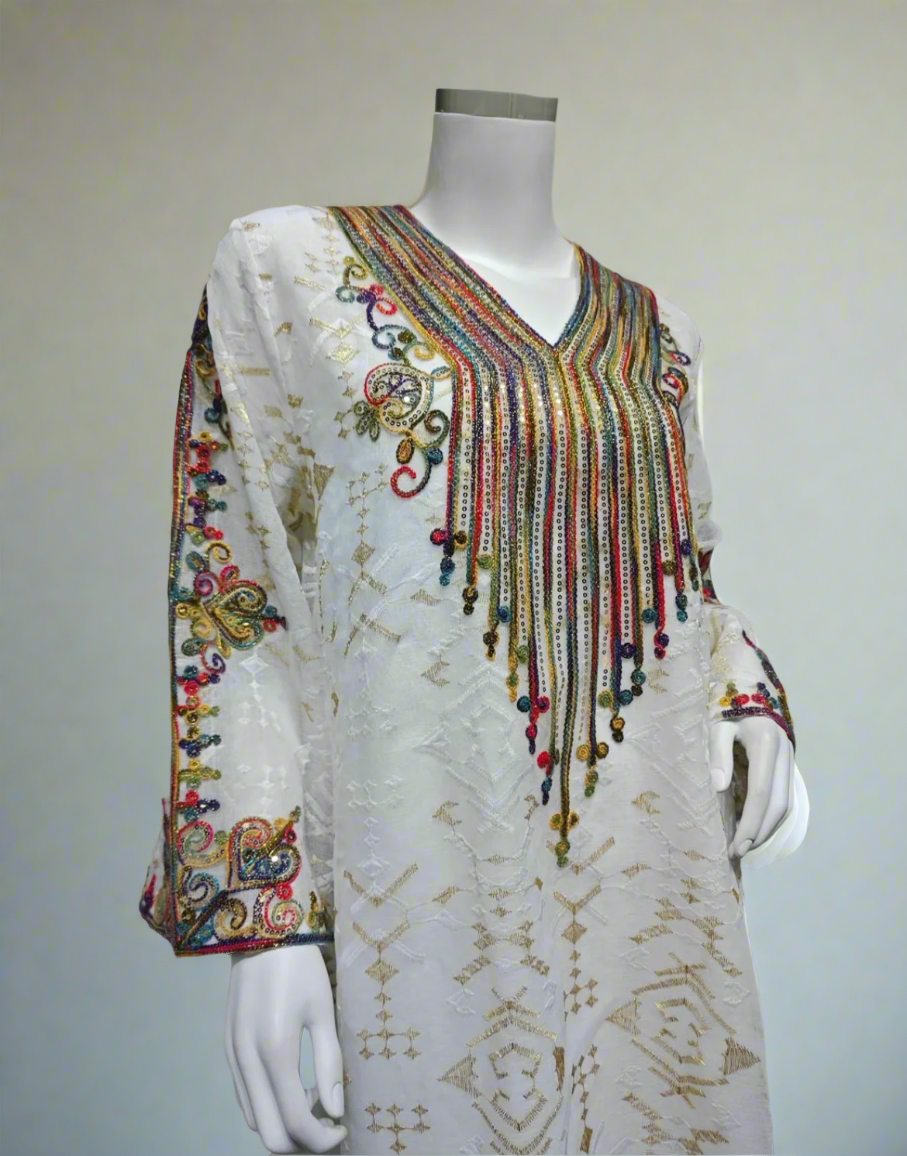 Mannequin wearing a white embroidered dress with colorful embellishments against a gray background