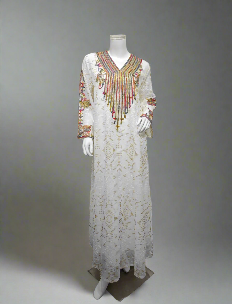 Long, floral dress with a colorful neckline on a mannequin against a white paneled wall.