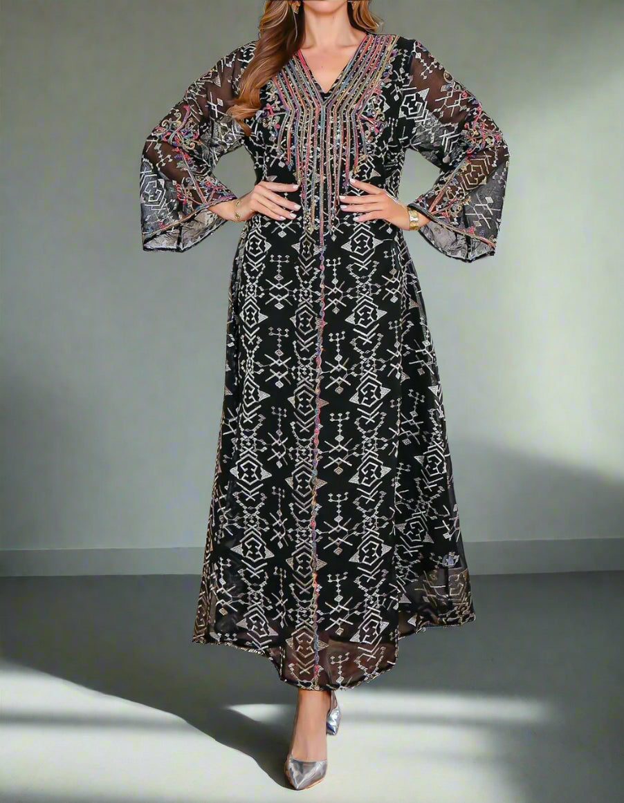 Woman wearing a long, patterned dress in a living room setting.
